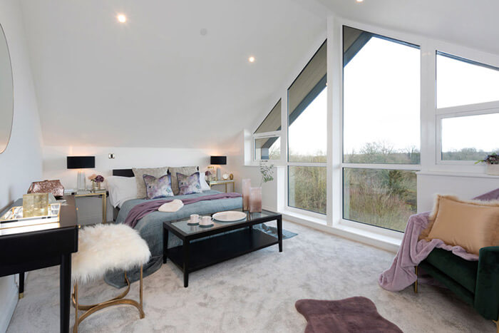 Professionally staged home by Beau Property Home Staging. Show home bedroom featuring colour matched/themed furniture, bedside tables, lamps and single corner seat