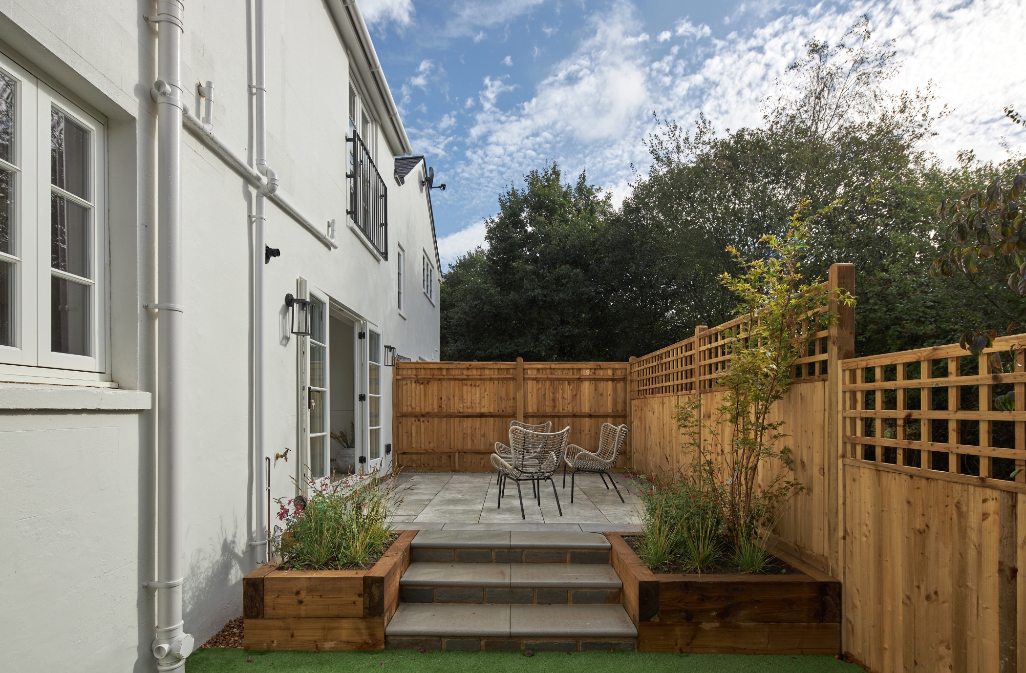 Charming and tranquil backyard with patio area and rattan chairs in a staged home in Tunbridge Wells, exemplifying the art of home staging.